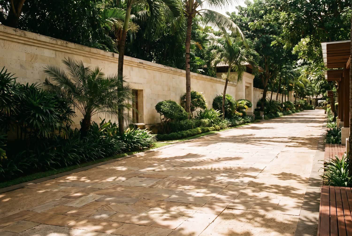 A wide planned resort avenue in Nusa Dua with manicured tropical planting and alternating bands of shade and sun.